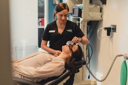 Healthcare provider examining patient's head and neck in clinical medical setting.