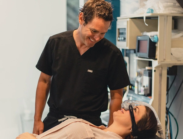 Male healthcare provider performing examination on female patient in clinical medical setting.